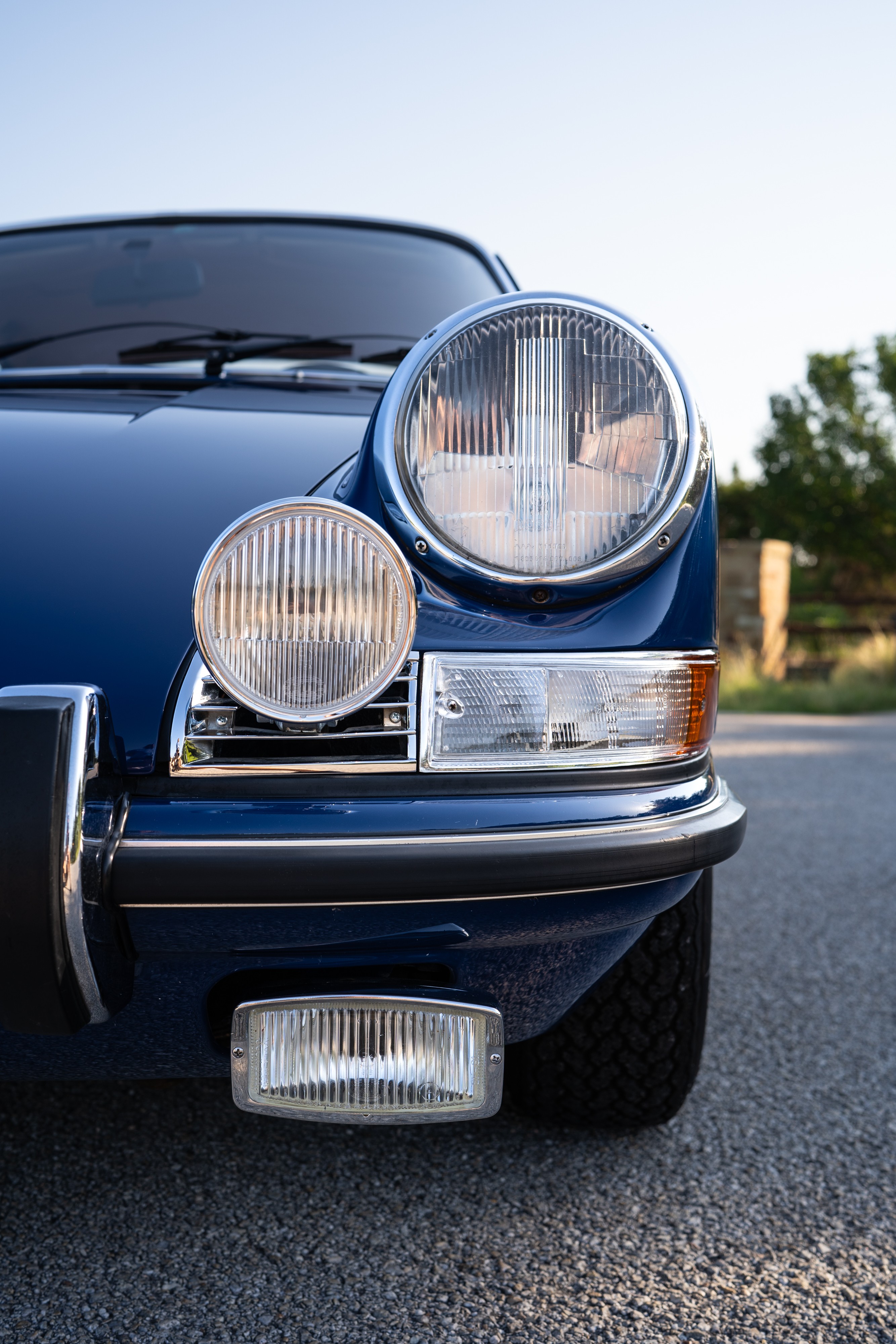 Headlights and fog lights on a 1969 Porsche 911S in Ossi Blue over Red.