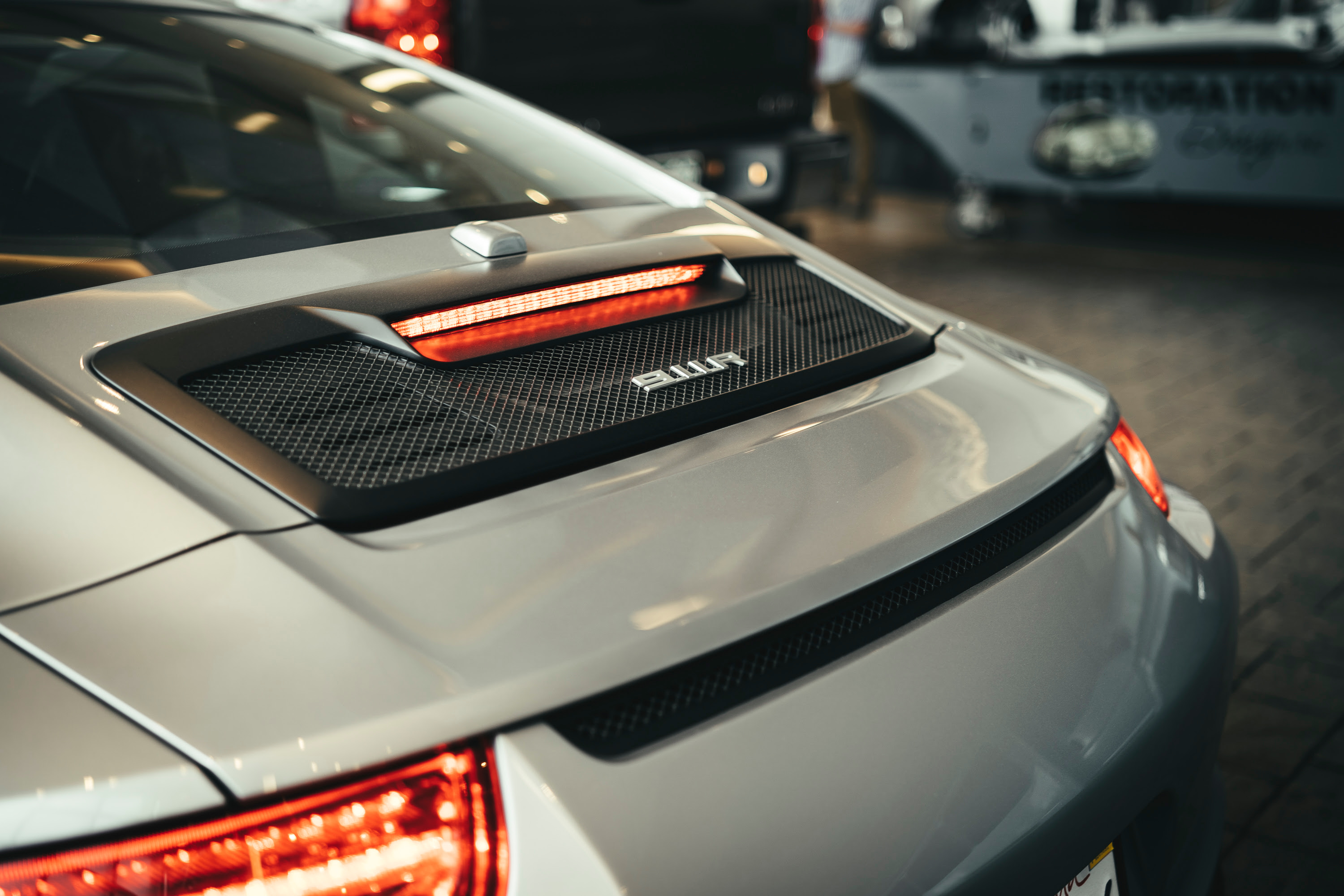 A silver Porsche 911R parked outside a hotel in LA.