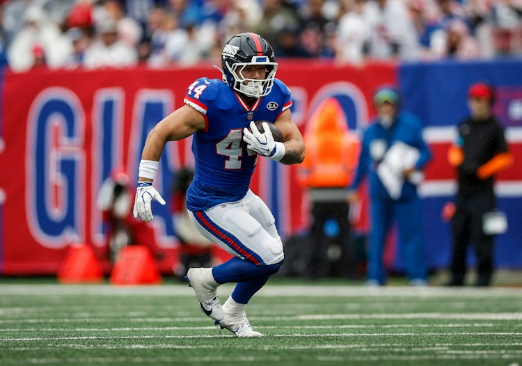 Giants running back Cam Skattebo carries the football during an NFL game.