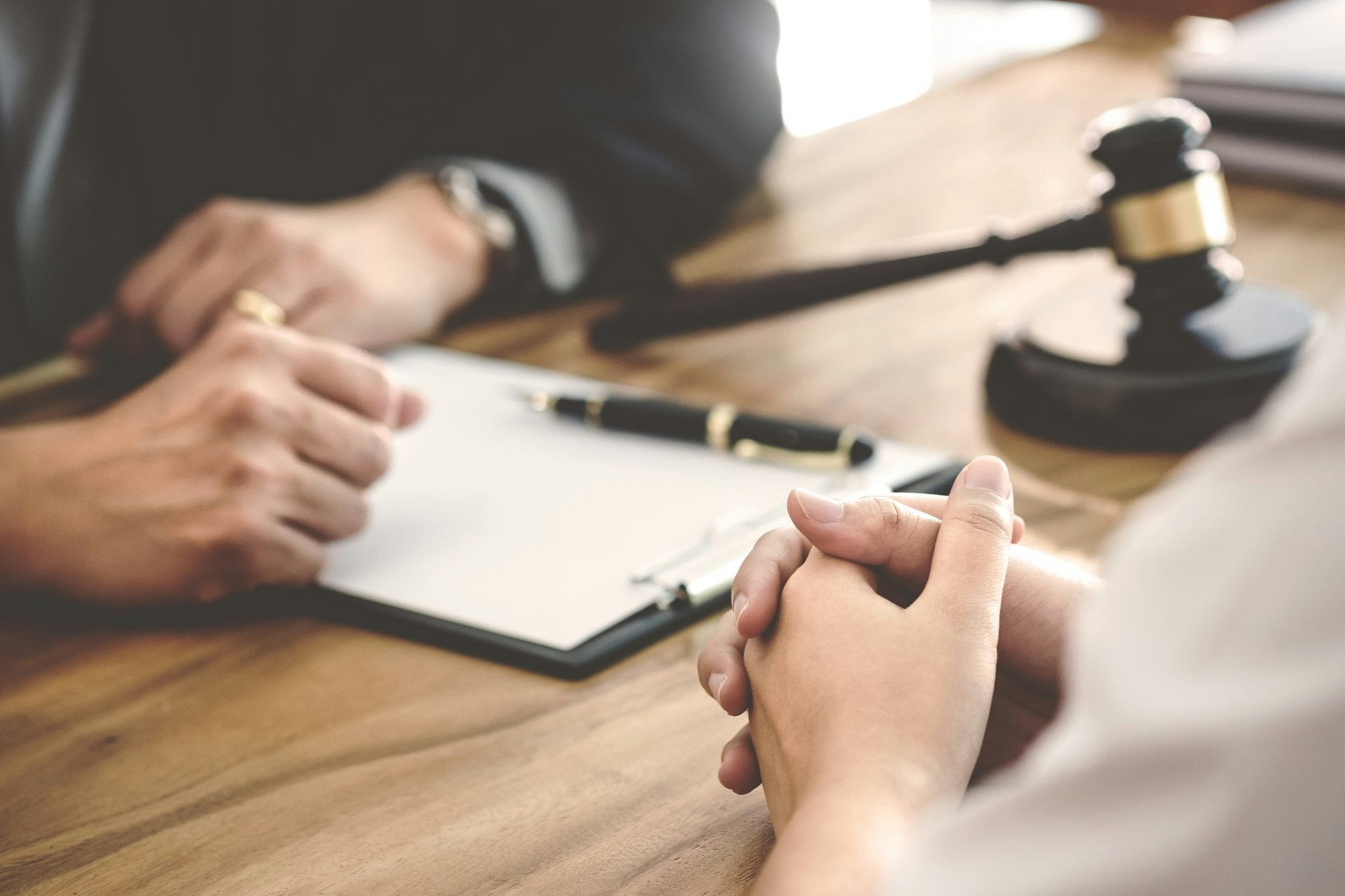 Hands of two people with paperwork and gavel discussing probate sale