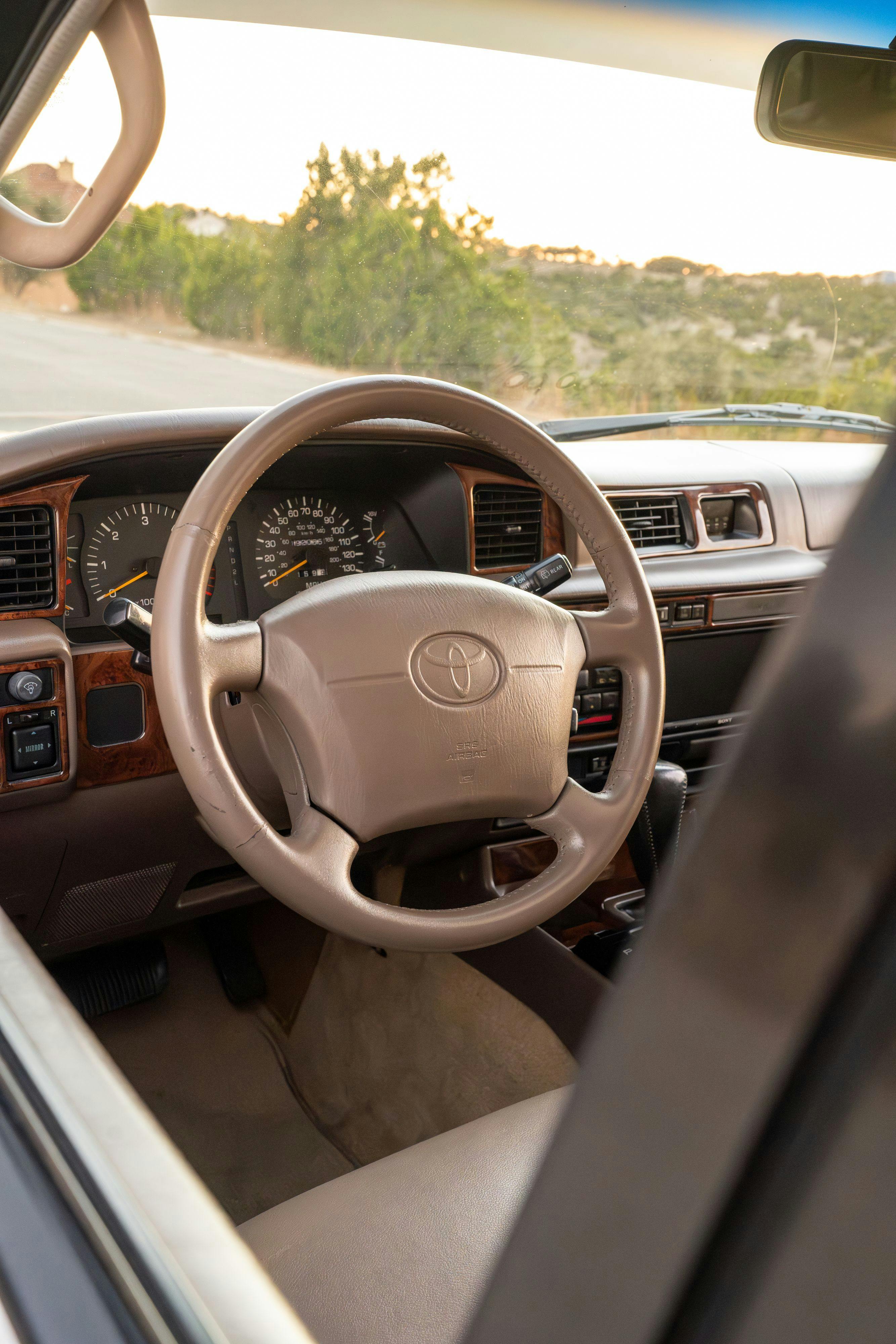1997 Toyota Land Cruiser FJZ80 steering wheel in Desert Dune Metallic with Moonglow Pearl cladding.