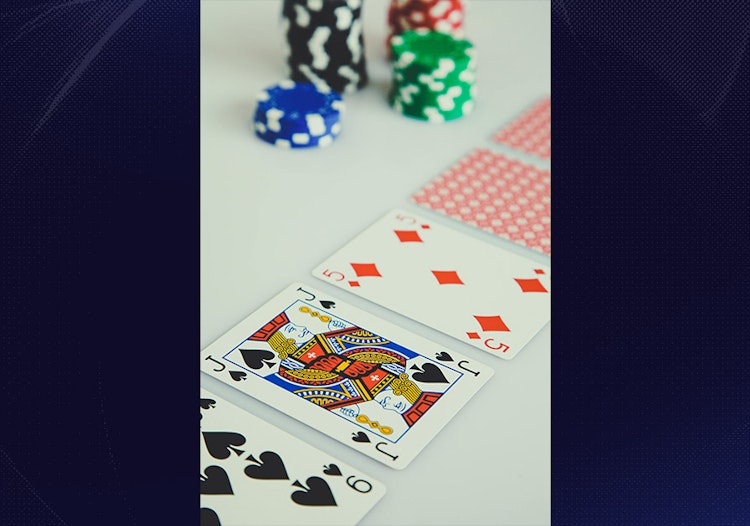 Poker chips and playing cards arranged on a table during a casino card game.