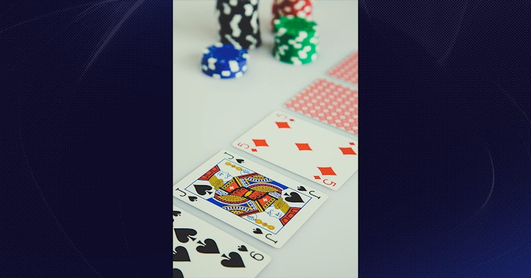 Poker chips and playing cards arranged on a table during a casino card game.
