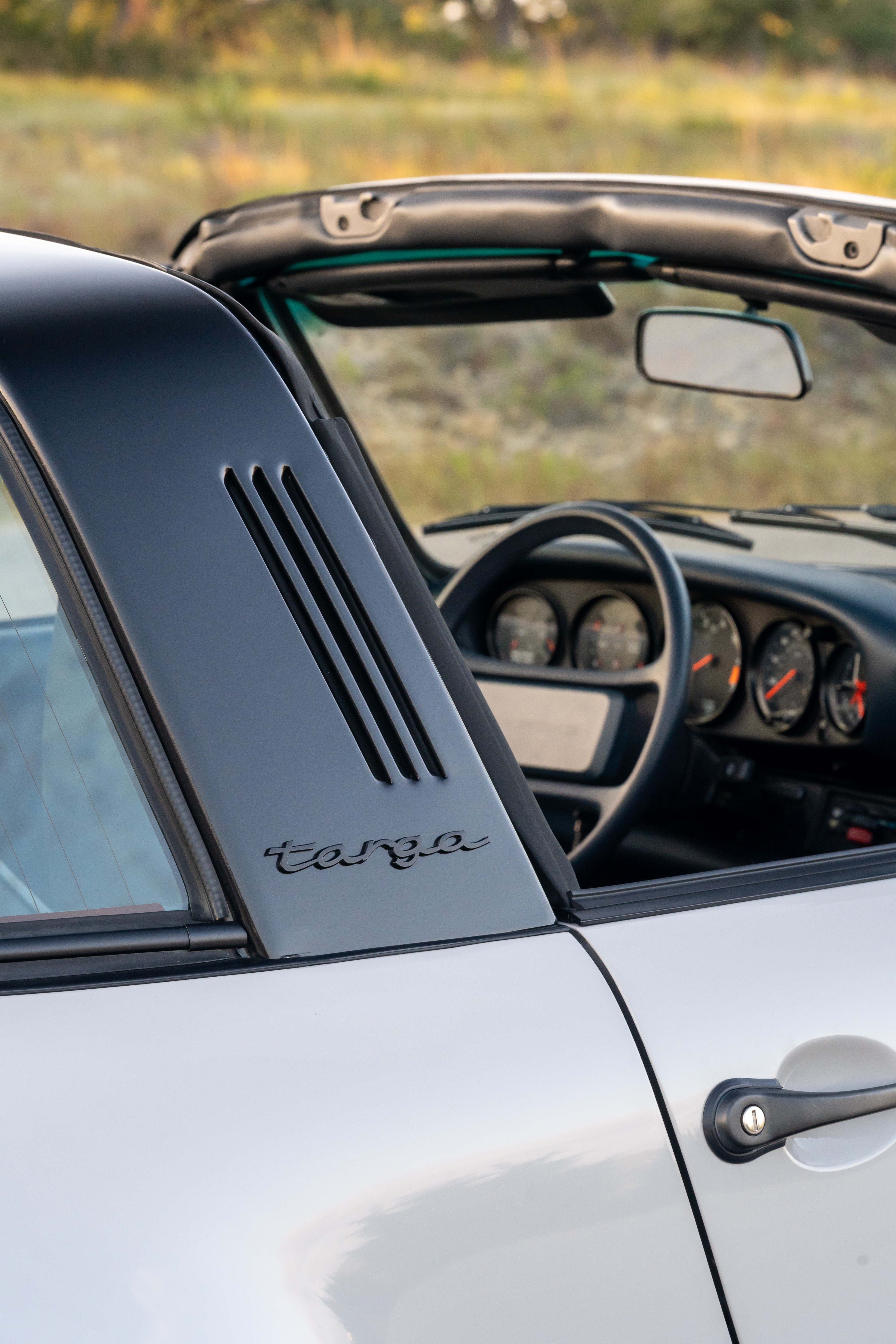 Marble Grey 1986 Porsche 911 Carrera Targa with blue interior shot in Austin, TX.