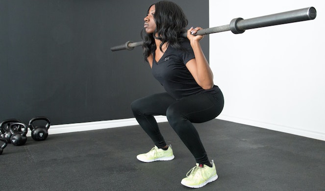 Woman doing power squats at her home gym