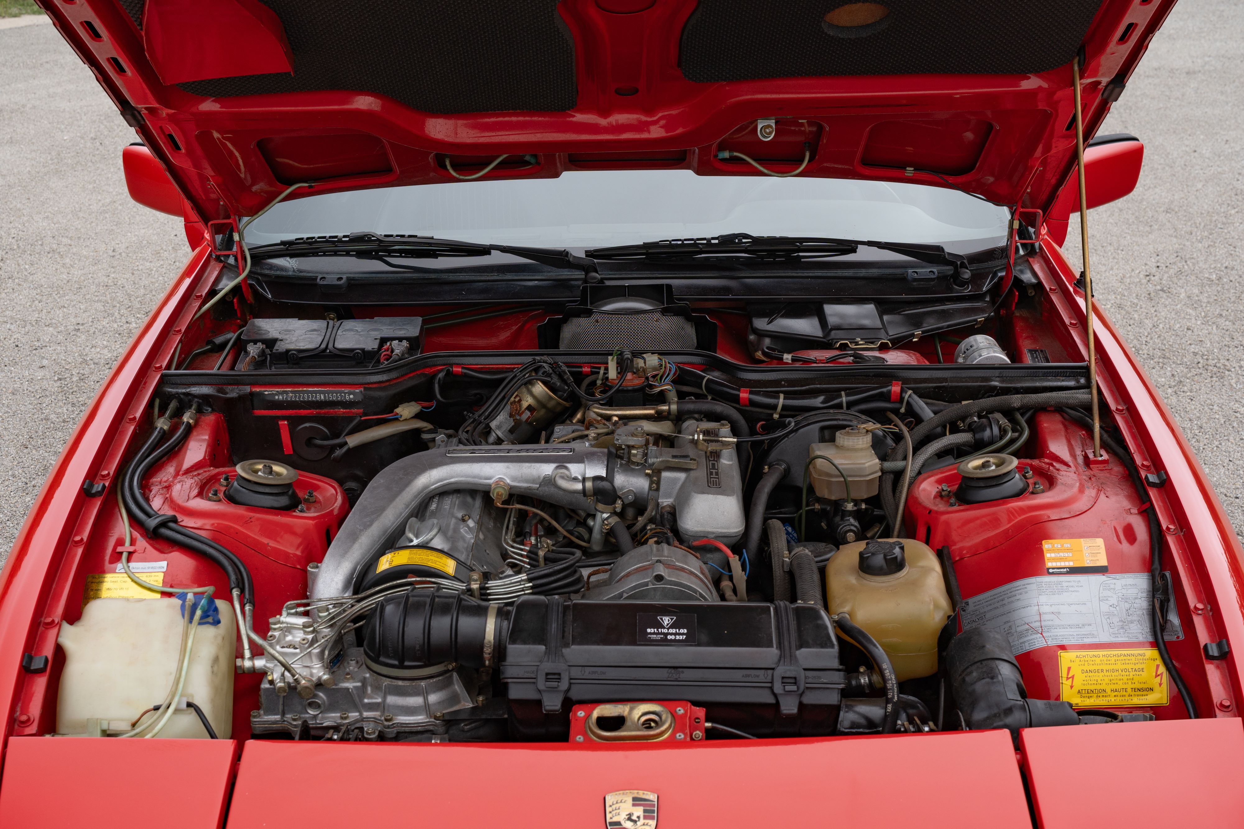 Engine bay of a Guards Red Porsche 924 Turbo in Dripping Springs, TX.