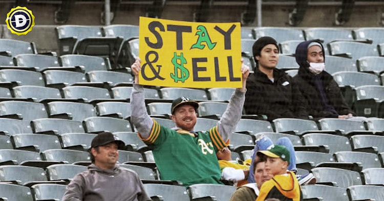 An Oakland Athletics fan holds up a "sell the team" sign.