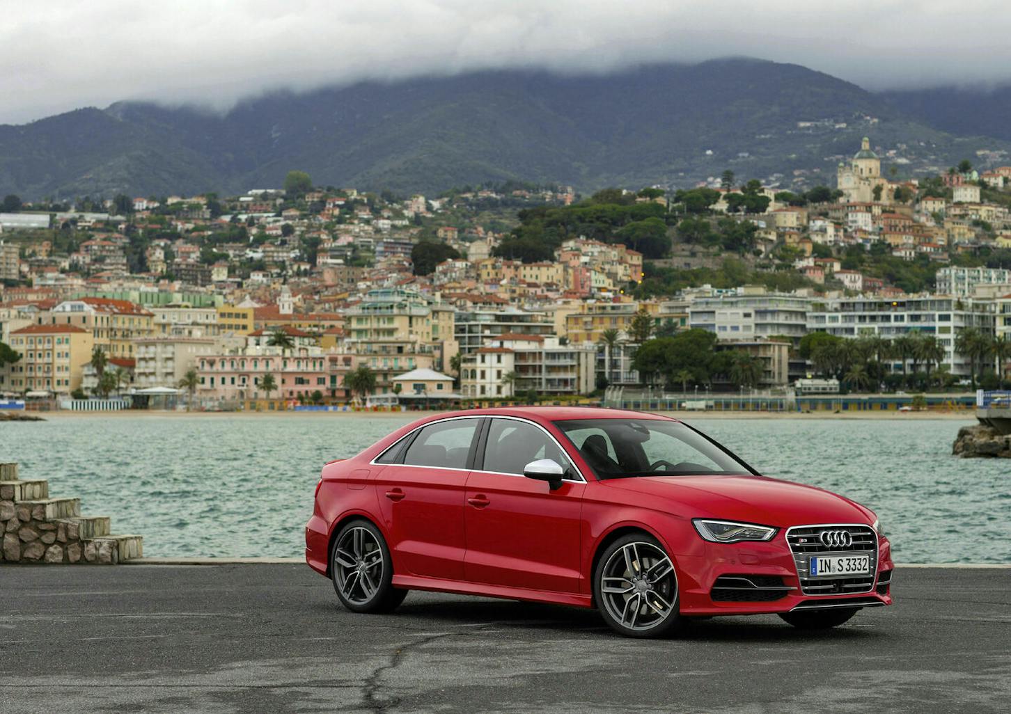 Eine rote Audi S3 Limousine steht an einem Hafen.