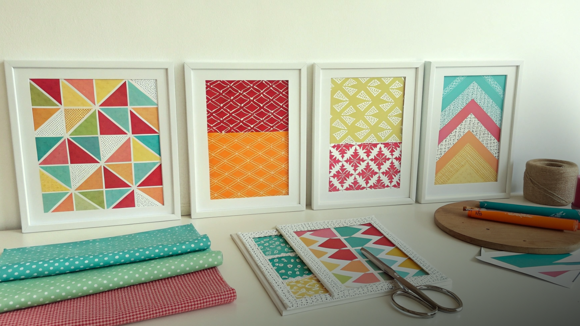 Quadros de tecido com estampas geométricas coloridas em parede-galeria.
