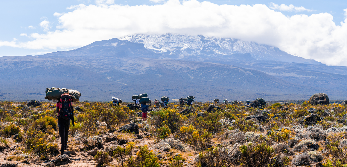Group-of-trekkers-hiking-among-snows-and-rocks-of-Kilimanjaro-mountain---The-Adventure-People.png