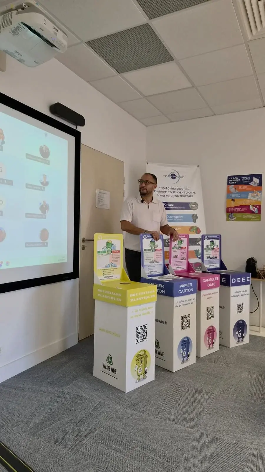 Les quatre corbeilles de tri WasteWize présentées aux équipes en salle de réunion