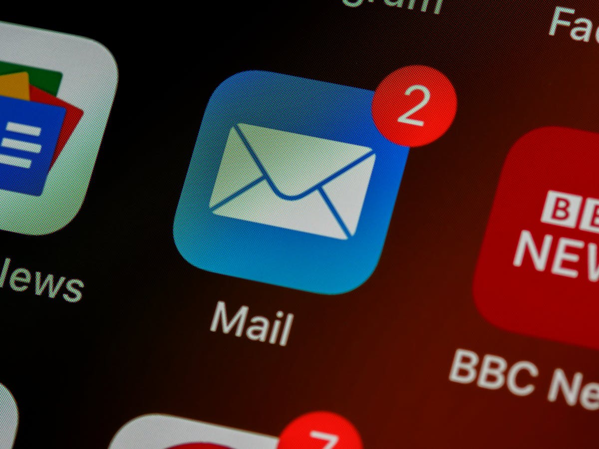 Close-up of an iPhone screen showing the Mail app icon with a red badge notification showing 2 unread emails, alongside BBC News and Google apps.