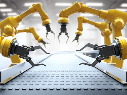 Bright yellow robotic arms working along an empty mechanic conveyor belt.