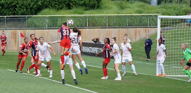 Corner kick action during women's soccer match