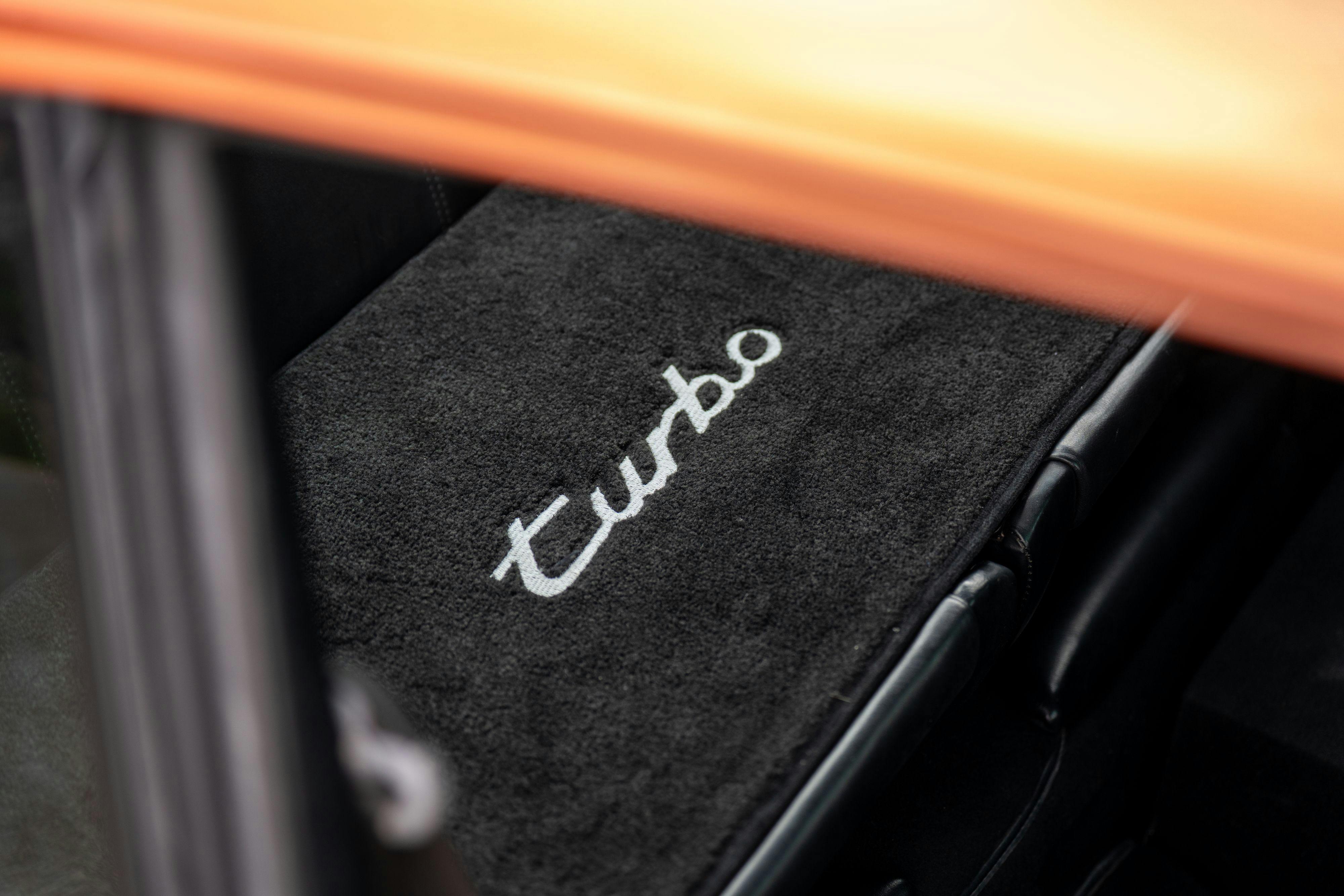 Turbo script carpet in a 1986 Porsche 930 Turbo in Metallic Orange over Black.