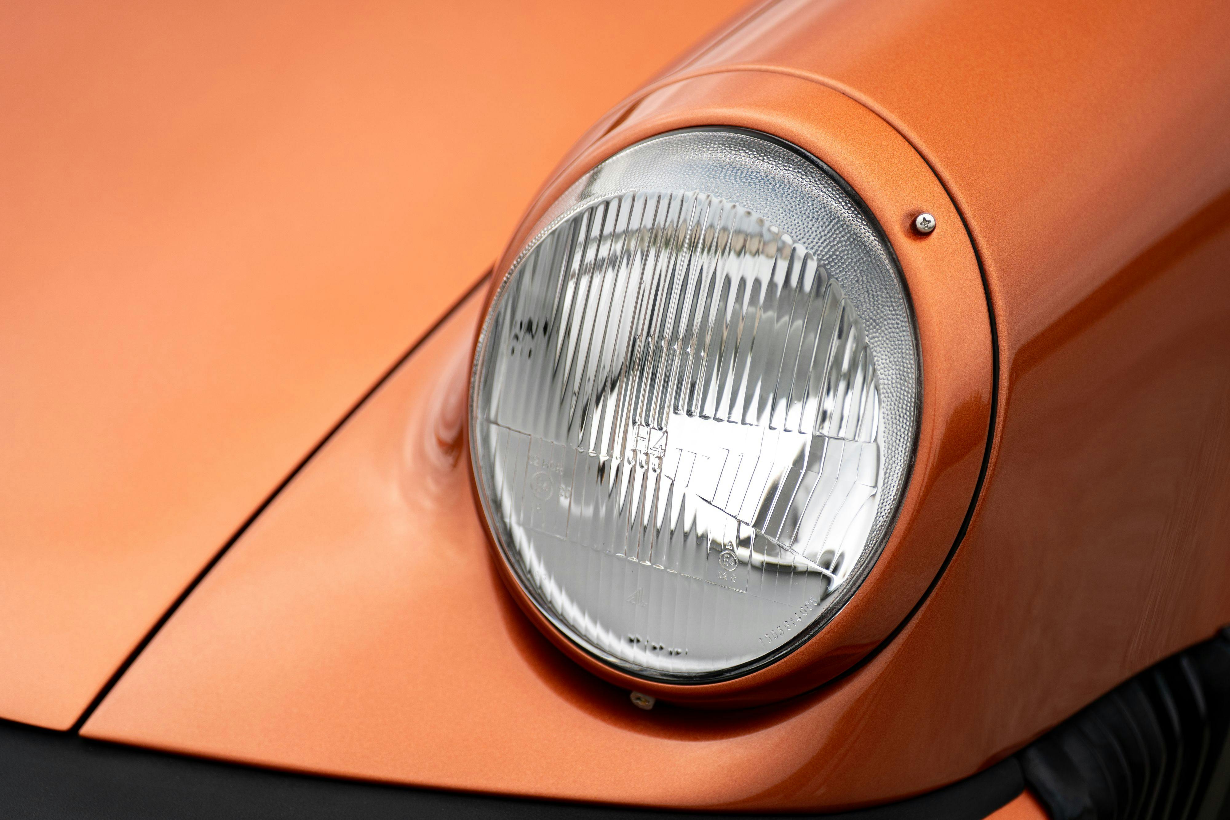 H4 headlight on a 1986 Porsche 930 Turbo in Metallic Orange over Black.