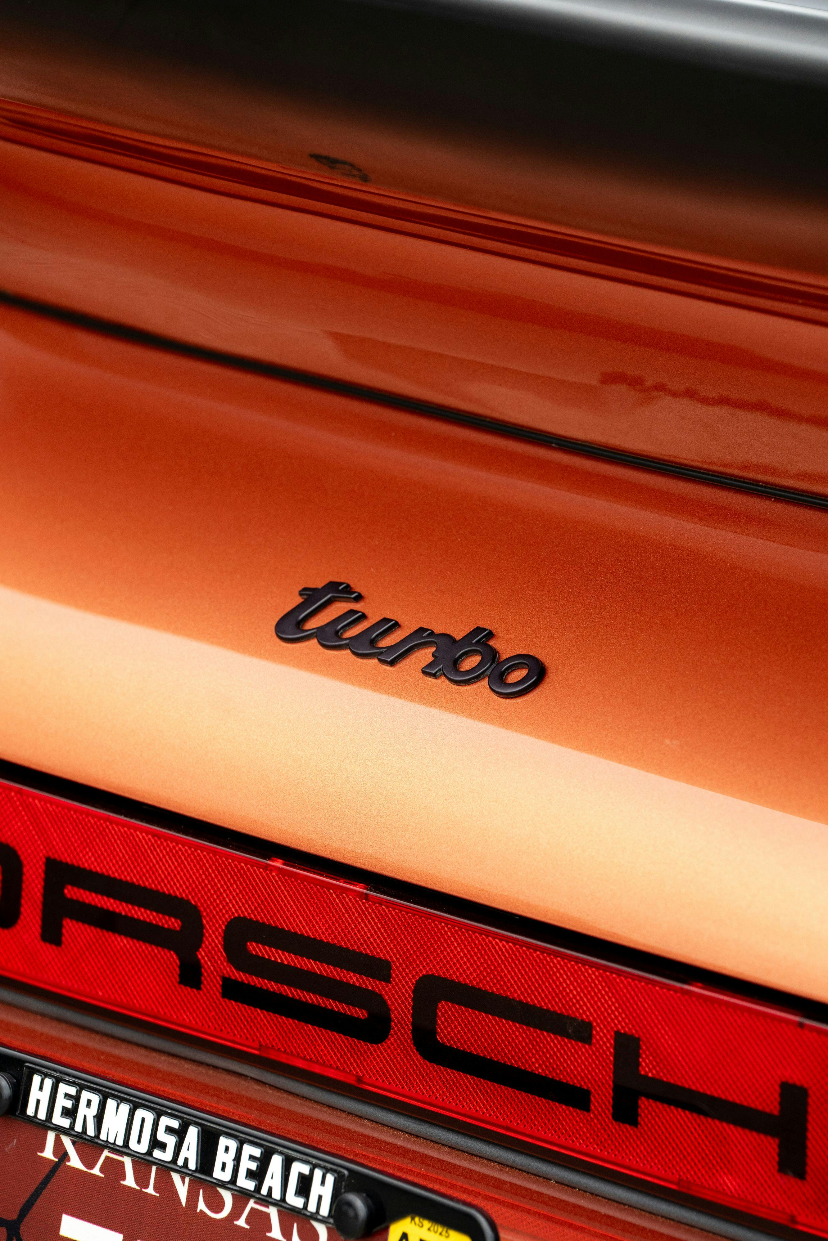 Turbo badging on a 1986 Porsche 930 Turbo in Metallic Orange over Black.