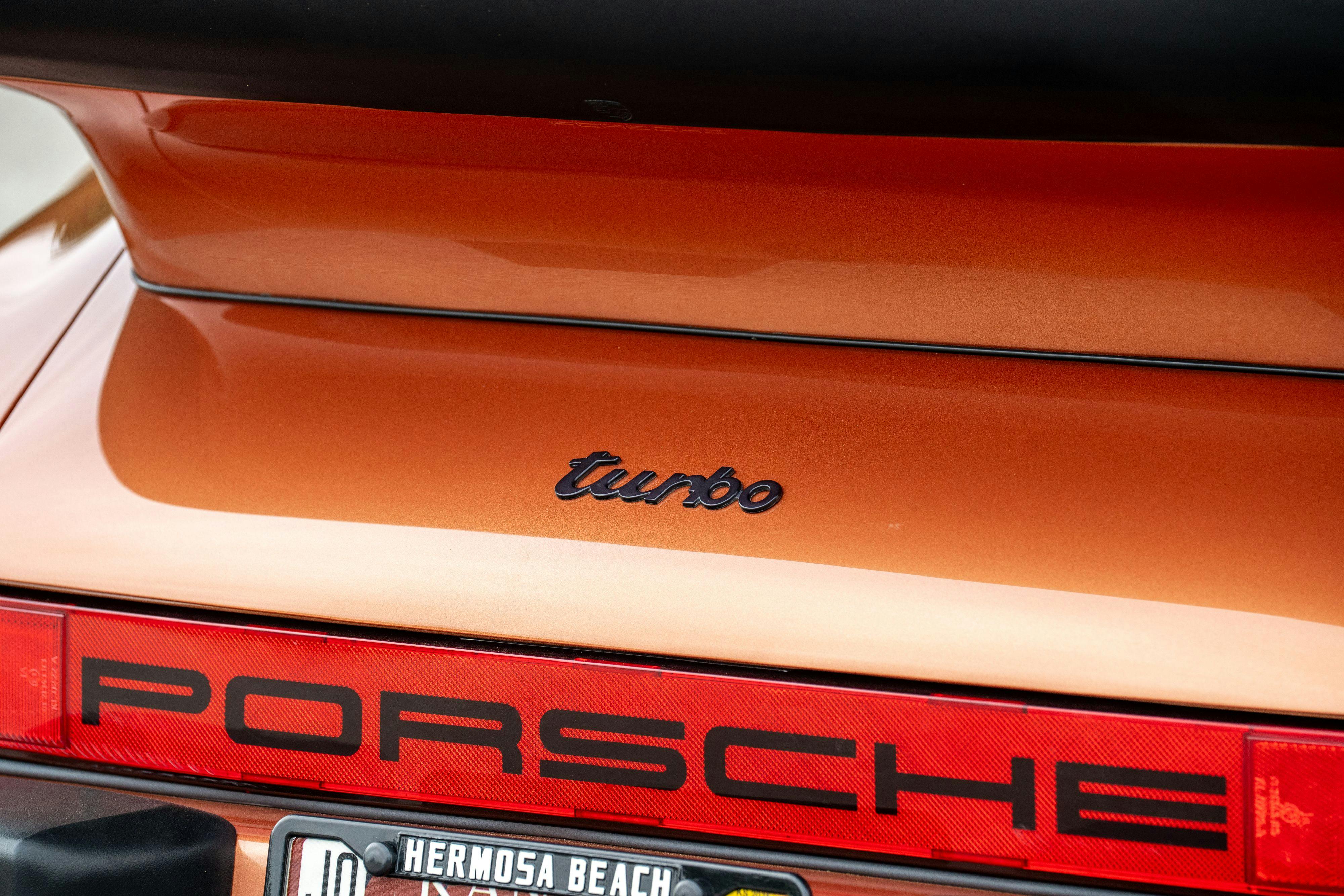 Turbo badging on a 1986 Porsche 930 Turbo in Metallic Orange over Black.