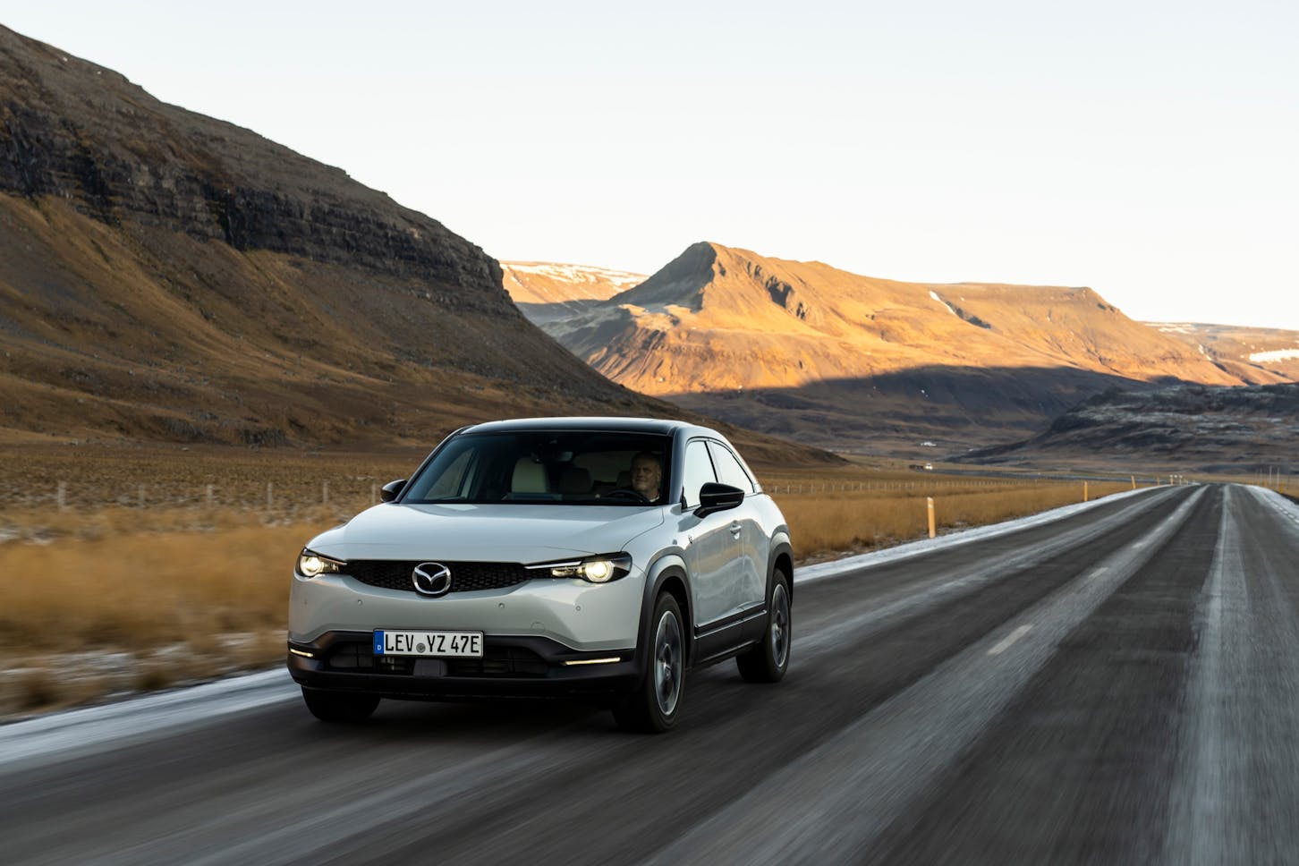 Der Mazda MX-30 e-Skyactiv R-EV fährt in einer Berglandschaft.