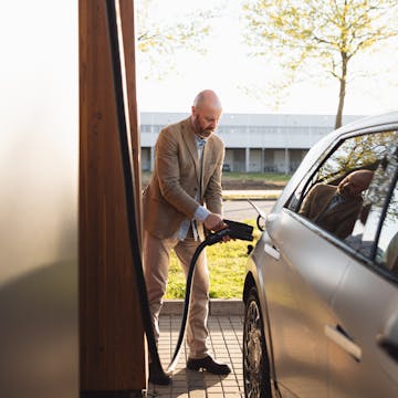 Ein Mann lädt sein Auto an einer Wallbox.