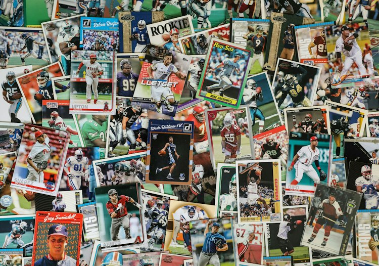 A collection of overlapping sports trading cards featuring football, basketball, and baseball players.