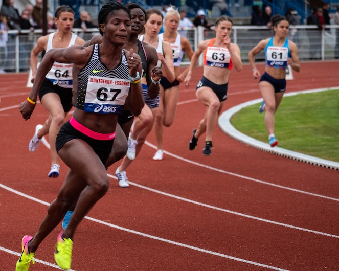 Women track runners rounding the corner during a race