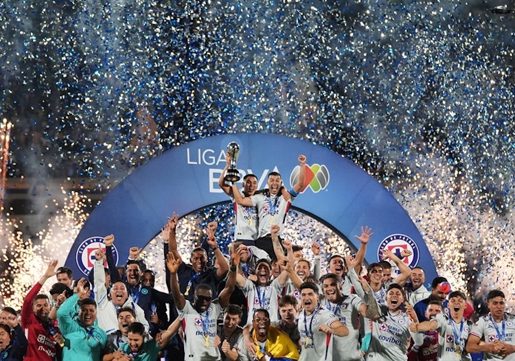 Cruz Azul's Carlos Rodriguez, top left, and Erik Lira lift the trophy after winning the Mexican soccer league final against Pumas in Mexico City, Sunday, May 24, 2026.