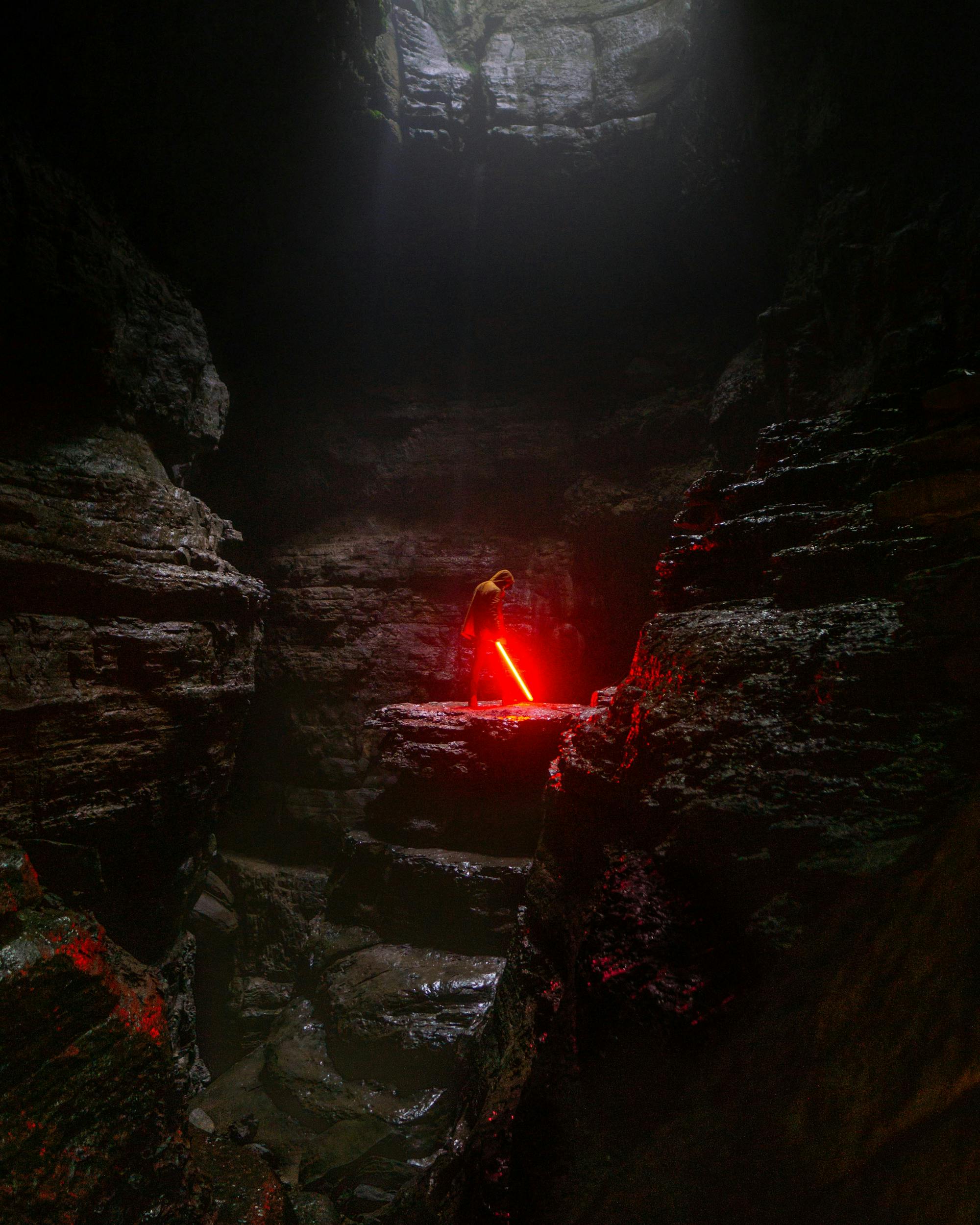 Jedi in a cave with a light saber.