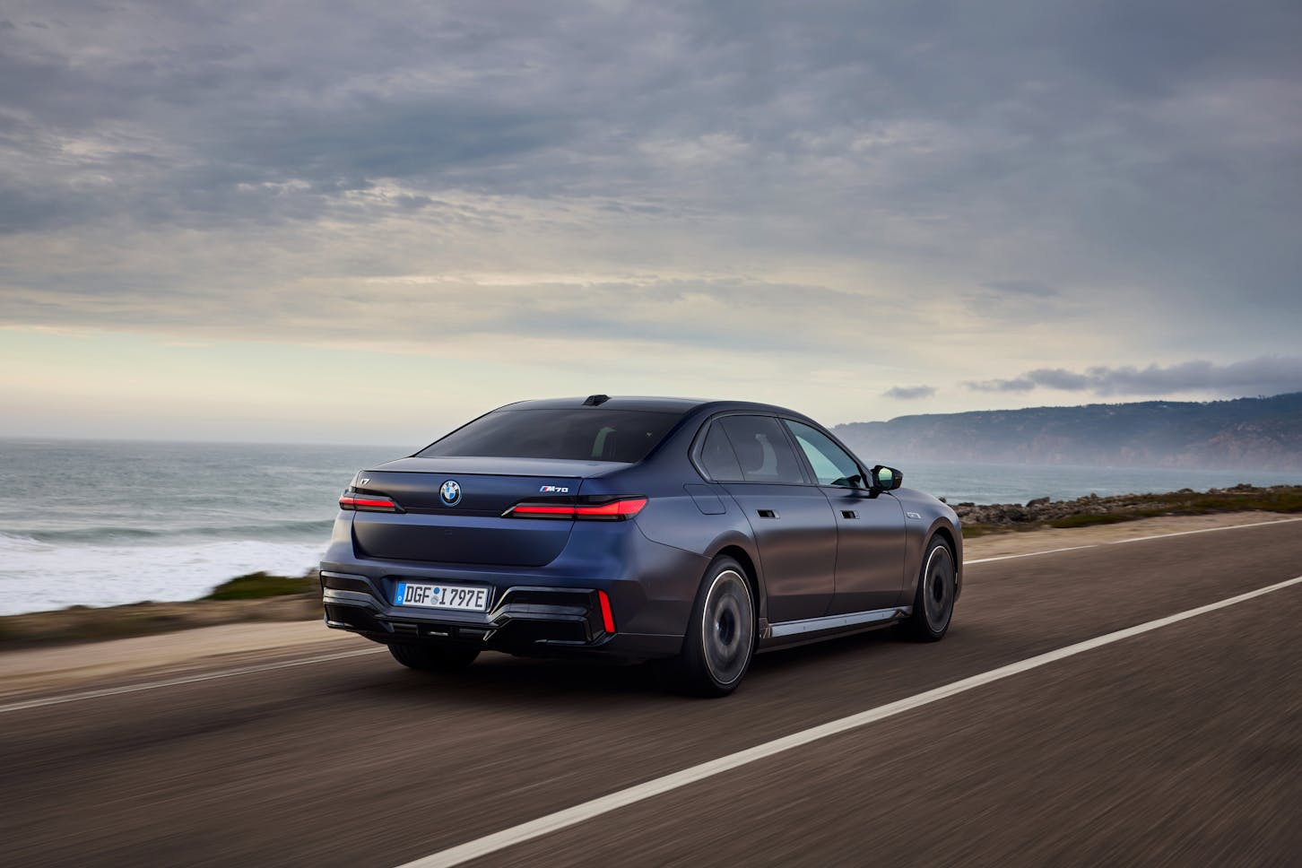 Die BMW i7 Limousine fährt am Strand entlang.