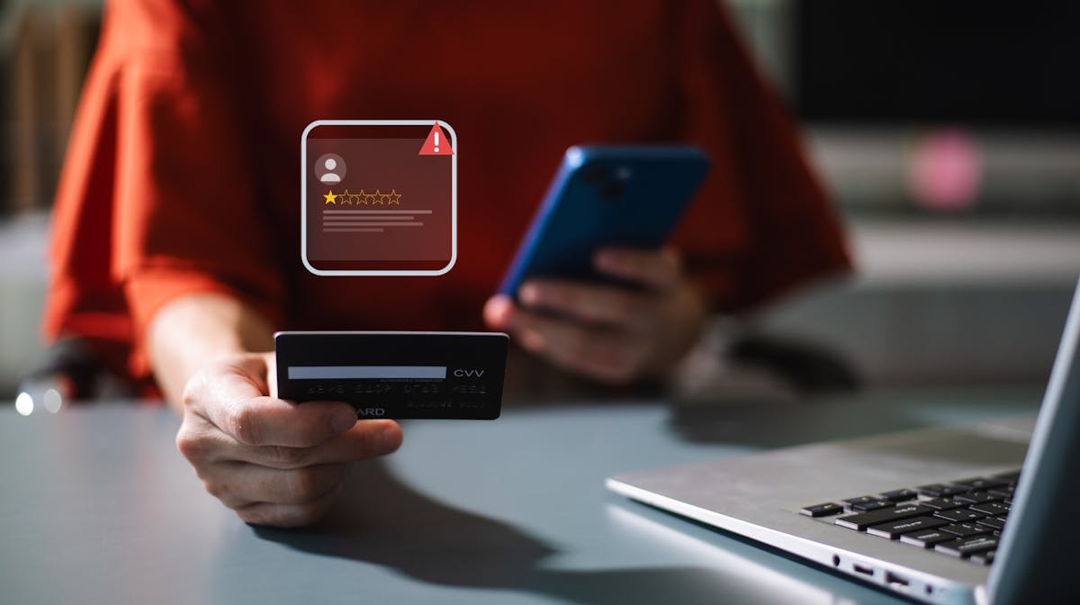 Person holding credit card and phone with a 1-star review warning, representing Facebook Marketplace scams