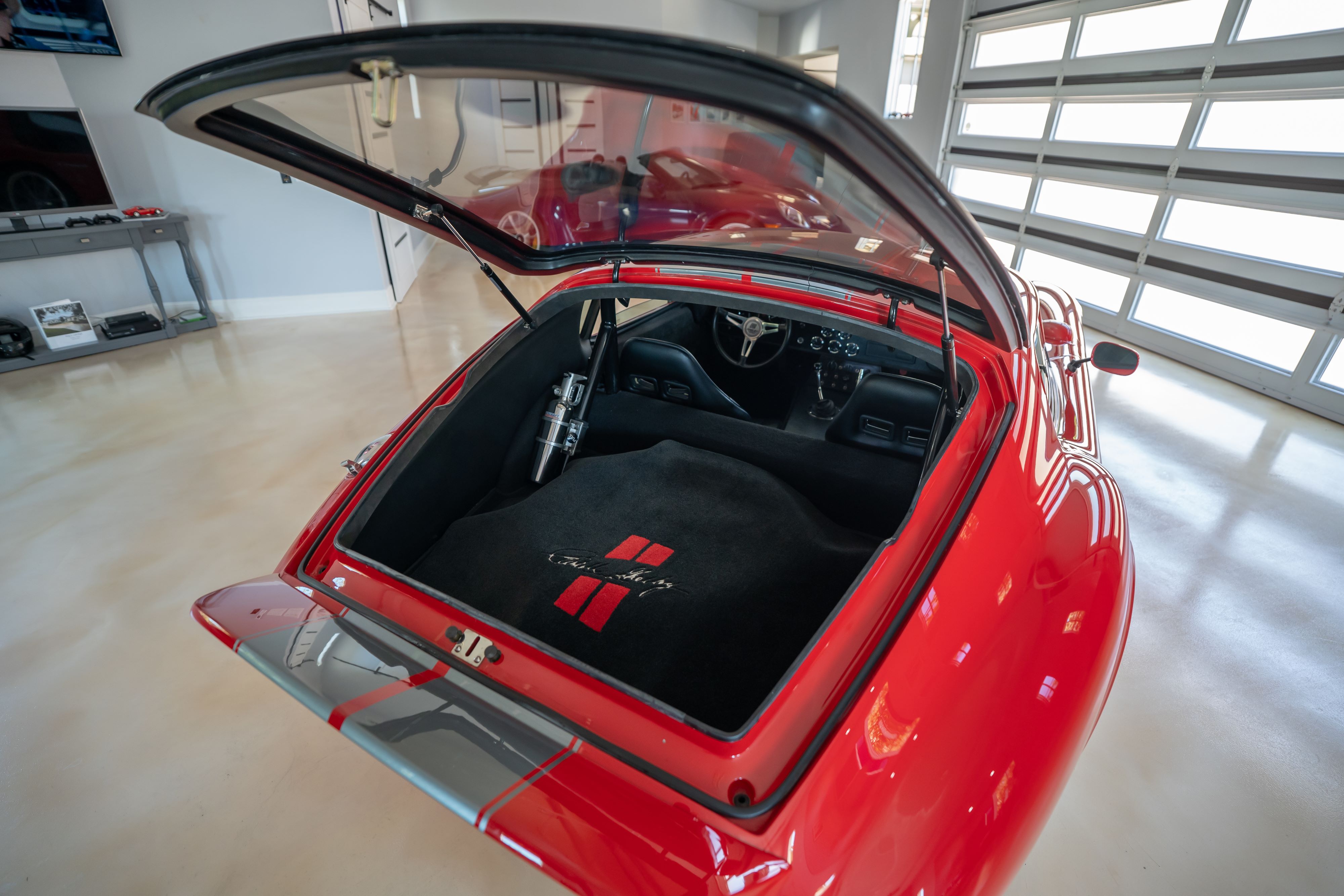 Trunk open on a 1965 Superformance Shelby Daytona CSX9000 in Monza Red.