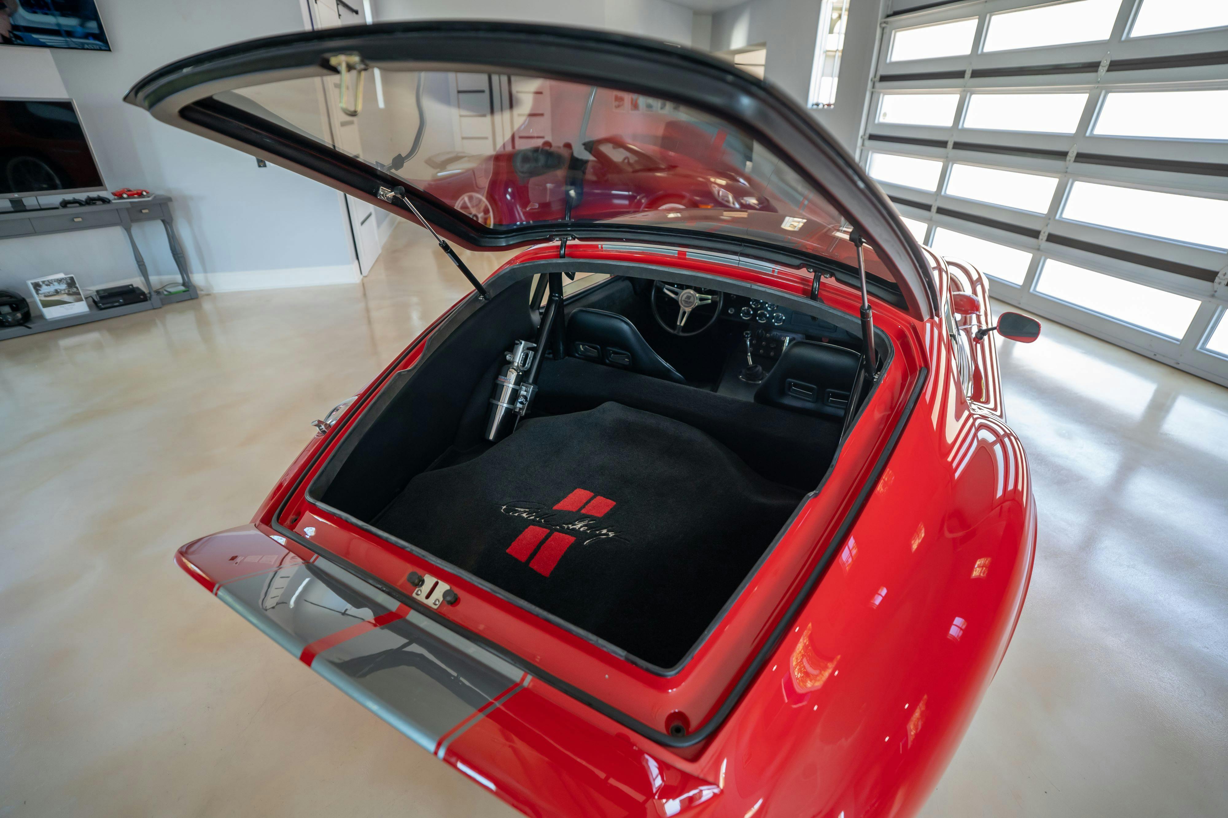 Trunk open on a 1965 Superformance Shelby Daytona CSX9000 in Monza Red.