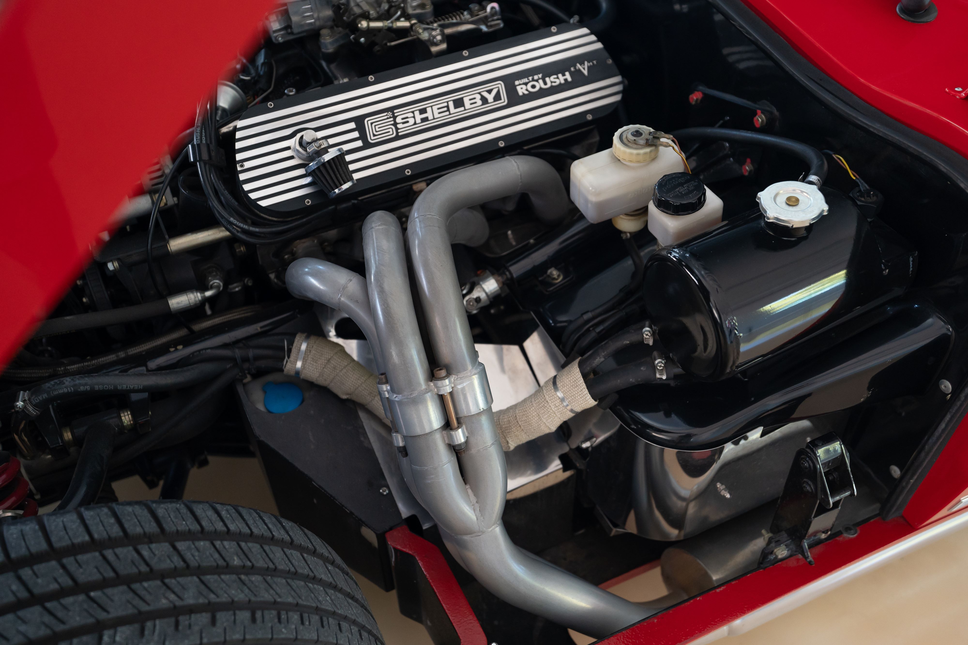 Exhaust headers in a 1965 Superformance Shelby Daytona CSX9000 in Monza Red.