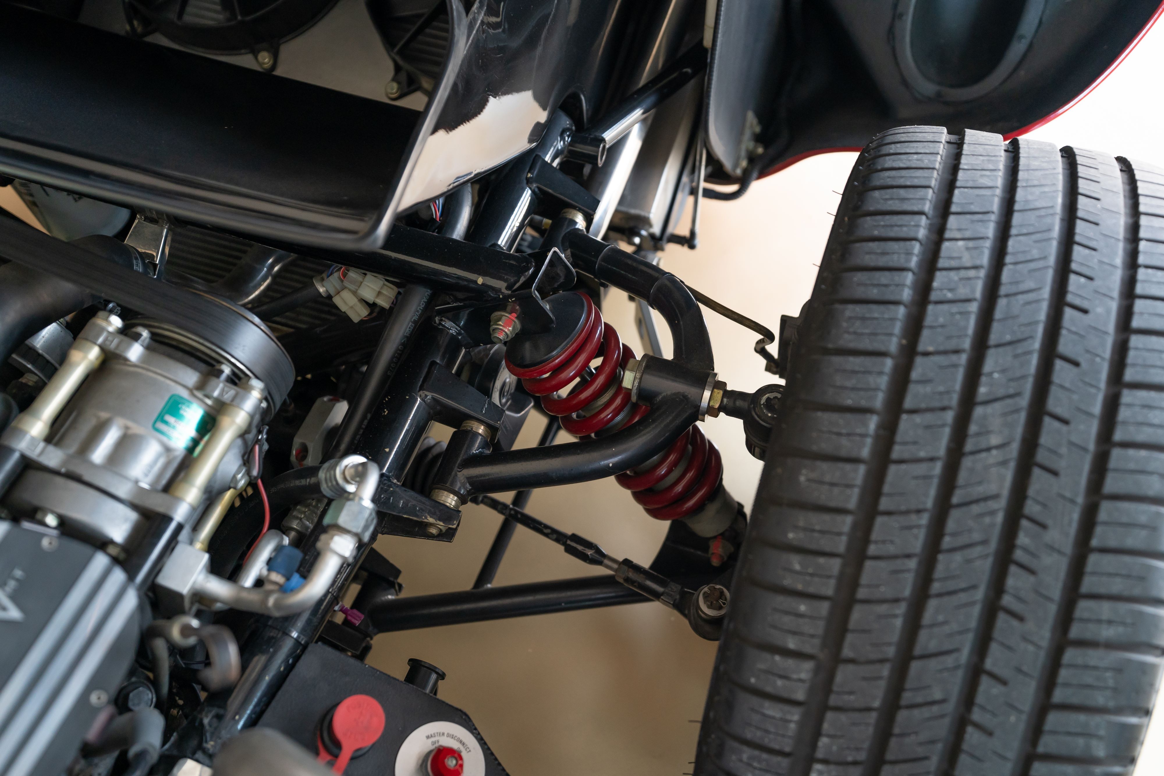 Front suspension on a 1965 Superformance Shelby Daytona CSX9000 in Monza Red.