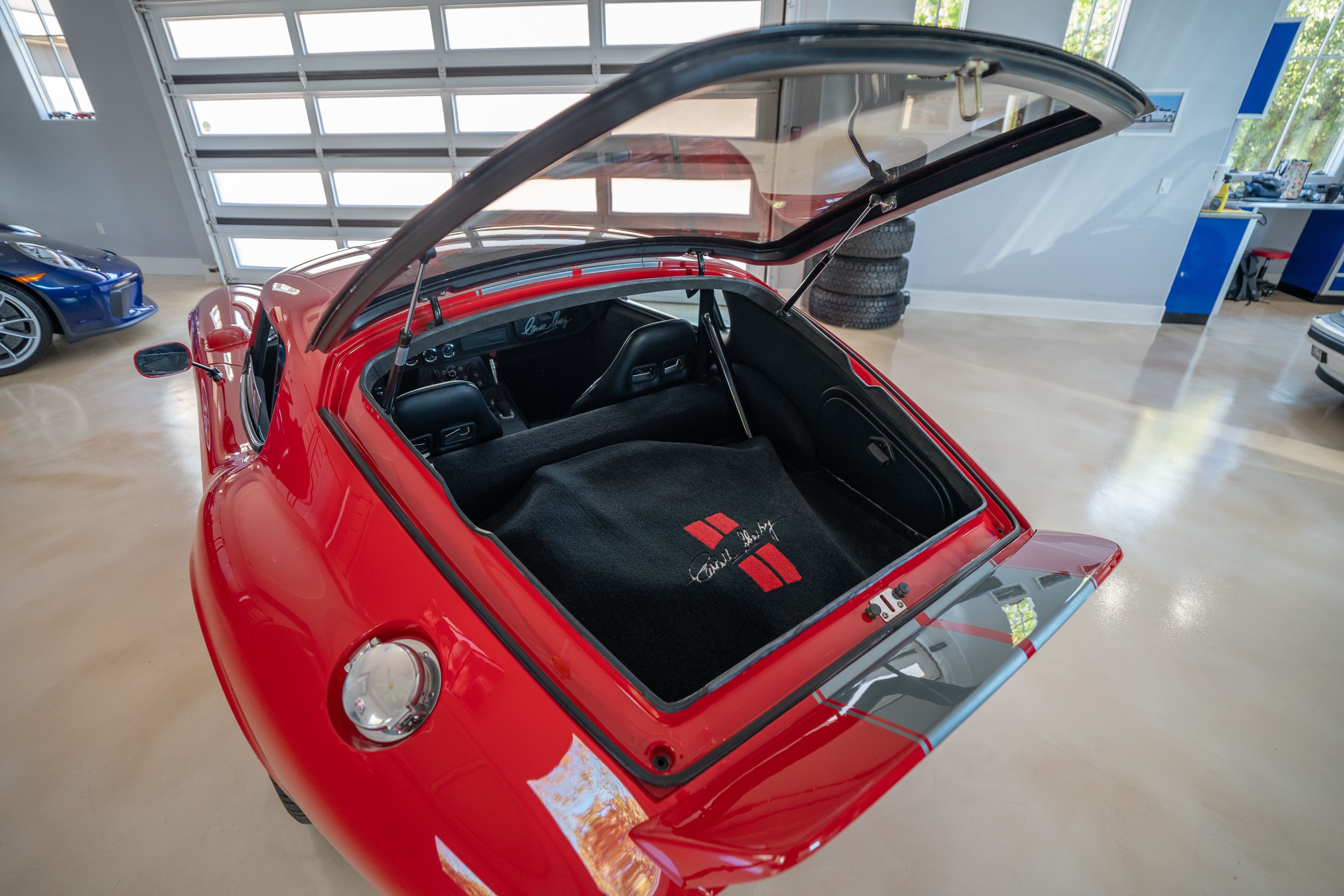 Trunk open on a 1965 Superformance Shelby Daytona CSX9000 in Monza Red.