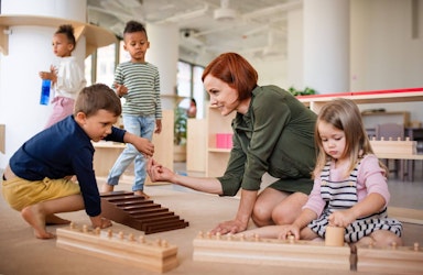 Montessori Daycare teacher playing with her students.