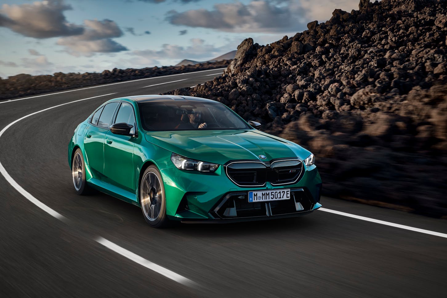 Die BMW M5 Limousine fährt in der Landschaft.