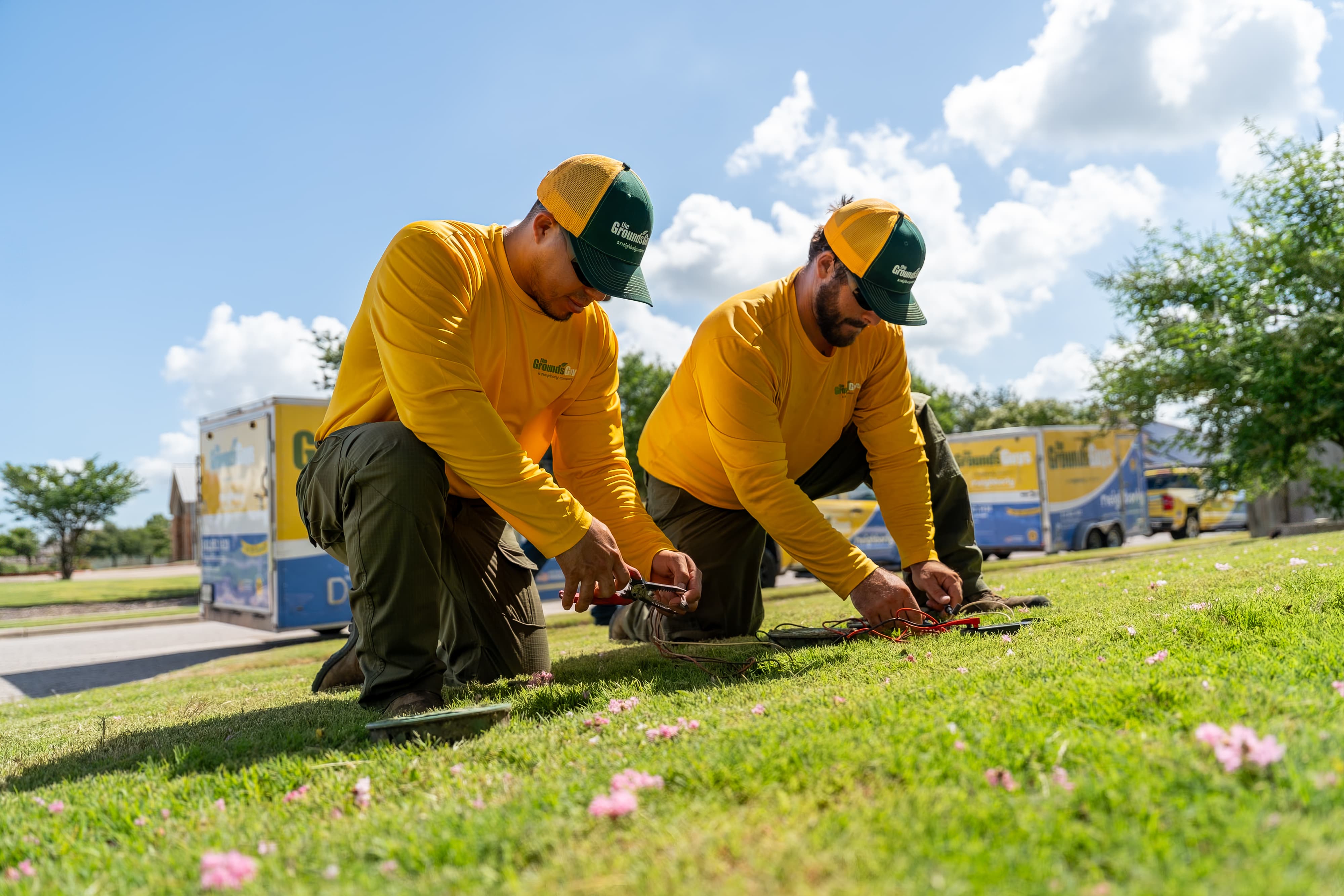 Grounds Guys maintenance crew doing yardwork and sprinkler maintenance.