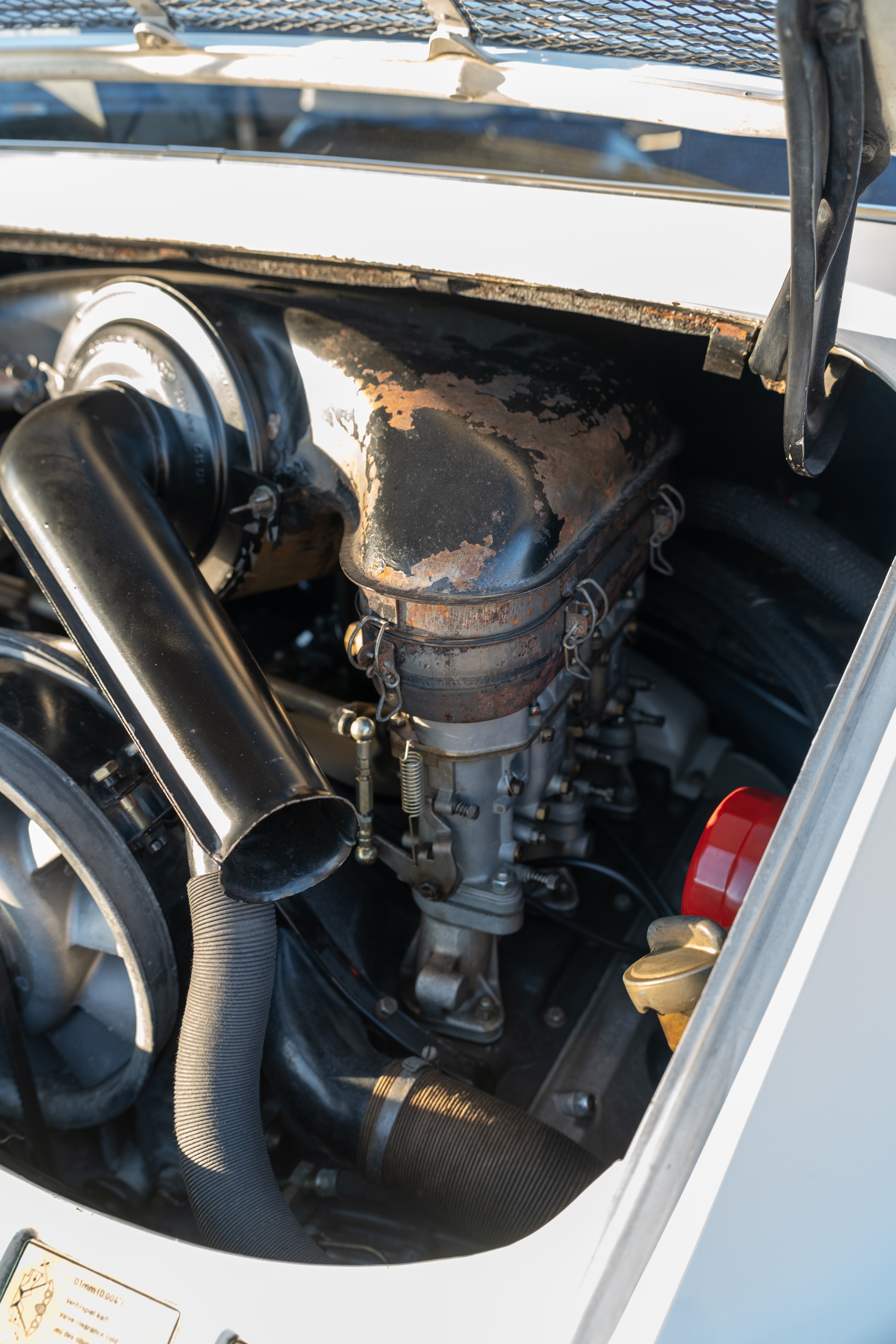 Engine bay of a White 1970 Porsche 911T Coupe with a black interior shot in Austin, TX.