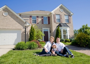 Nice family sittin on the lawn in front of their home