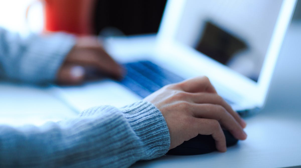 Person managing their cybersecurity protection account subscription from their laptop