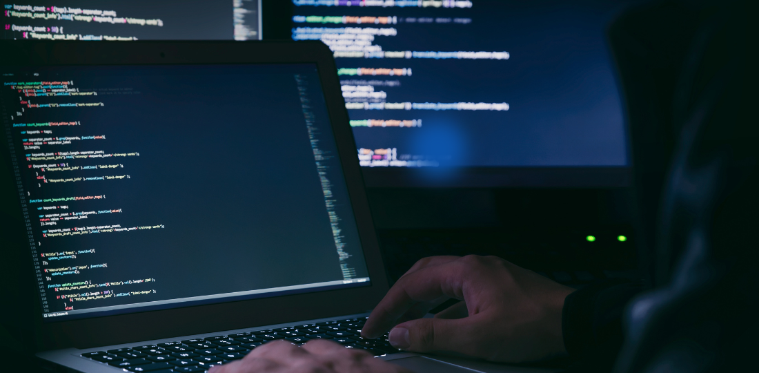 online hacker coding on laptop