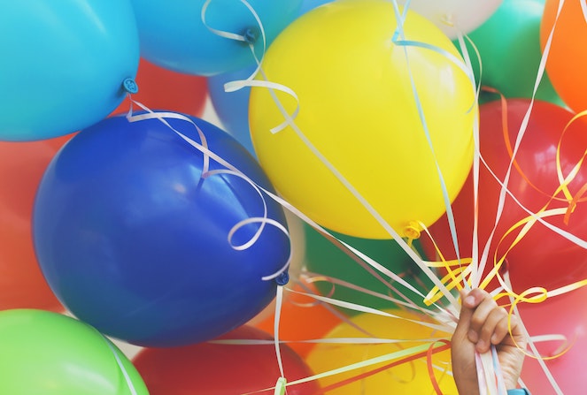 Hand holding a bundle of balloons